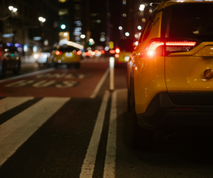 Stylish yellow SUV automobile driving on city street at night | Frederick, MD